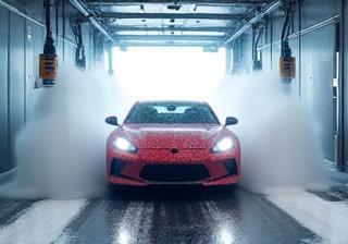 Car progressing through the automated wash tunnel with foam and brushes